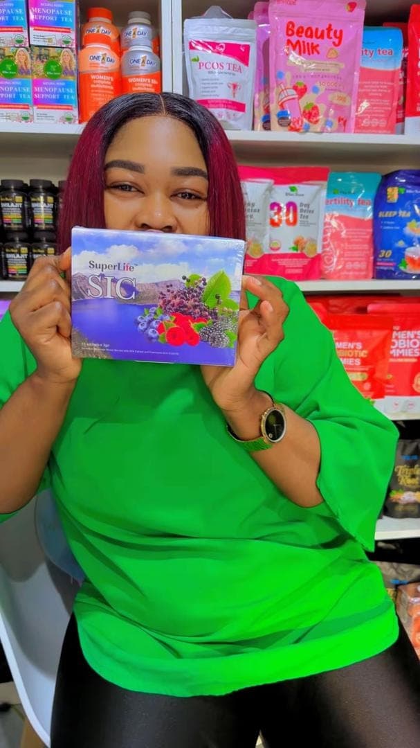 The founder holding a SuperLife product in front of the shop shelves